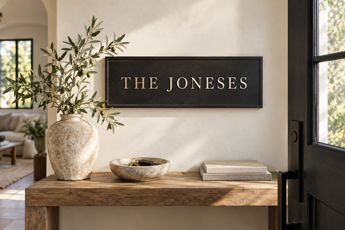 The Joneses lettering on a contemporary entryway plaque beside a key bowl; AI-generated concept.
